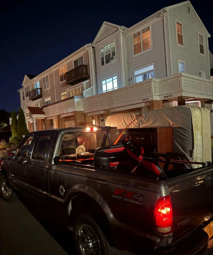 Bennett's F-250 loaded with a mattress and furniture on an evening junk removal run at a Loudoun County townhome