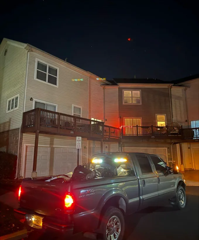 Truck staged with work lights on for an after-hours junk pickup at a Northern Virginia townhome