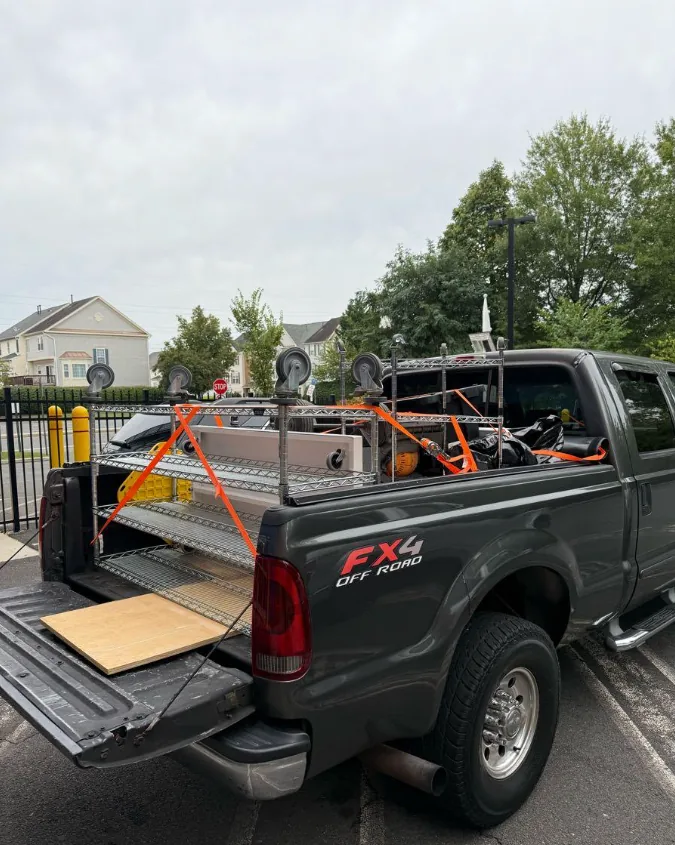 Wire shelving racks and equipment strapped down in the truck bed for a commercial move-out