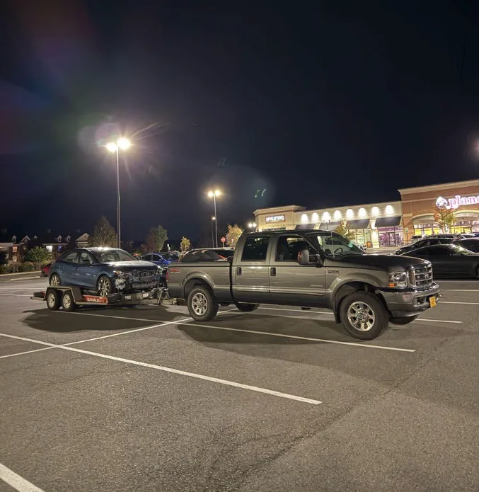 Car loaded on a tandem-axle trailer for an after-hours vehicle haul